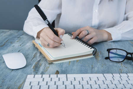 secretary write down plans for the day in a notebook
