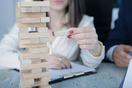 teamwork; girl builds a tower of wooden sticksの写真素材