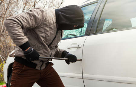 a thief is trying to steal a car; social problem conceptの写真素材