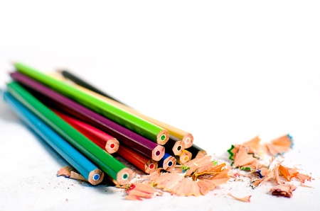 Colored pencils and pencil sharpening on a white background の写真素材