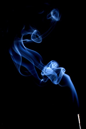 Blue smoke coming from an incense stick making figures の写真素材