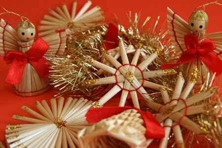 Straw christmas decoration on red backgroundの写真素材