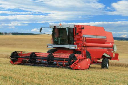 Red combine harvester in field