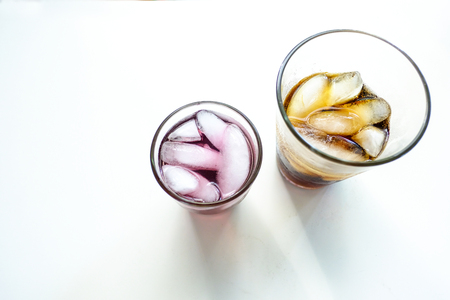 Two glasses of water are placed on a white table.の写真素材