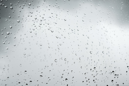 Heavy rain outside the window makes the glass island water.の写真素材