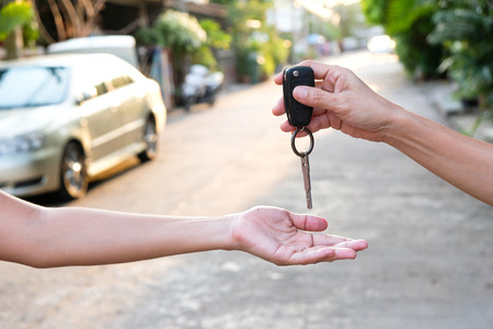 Young businessmen submit car keys toの写真素材