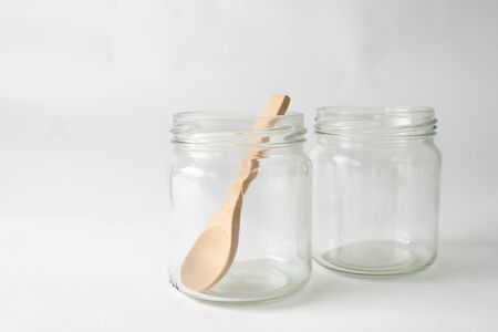 Two glass cups with a brown wooden spoon placed on a white backgroundの写真素材