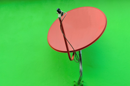Satellite dish on green wallの写真素材