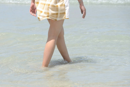 Female leg walking on the beach in the ocean