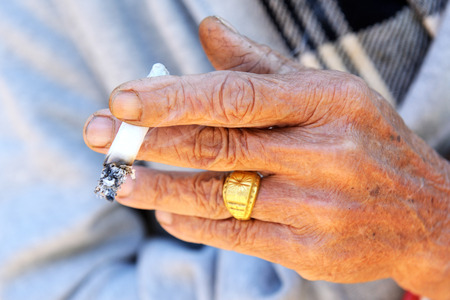 Old man holding cigaretteの写真素材