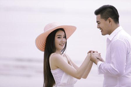 couple in love. couple on the beach. Smiling couple holding hands on the beach. Asian woman, Caucasian man. Travel Vacation Retirement Lifestyle Concept.
の写真素材