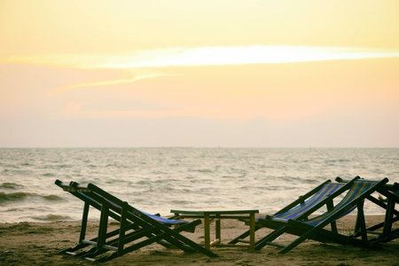 Empty beach chair on the beautiful tropical beach and sea at sunset time.の写真素材