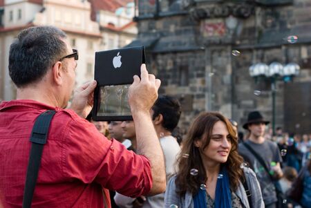 man taknig photo with apple during bubble day in Prague
