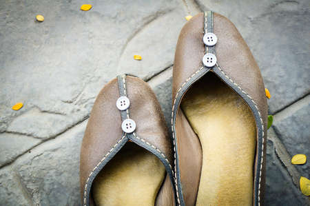 Pair of leather woman shoe on the black tile floorの写真素材