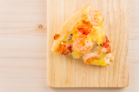 Seafood pizza on wooden plate on wooden background from top view with copy space, selective focusの写真素材