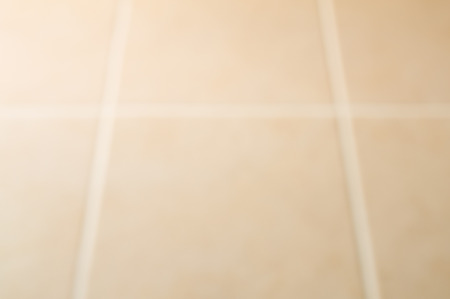 Blurred of cream tile floor with window light from the leftの写真素材