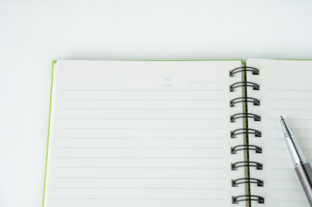 Open notebook with metallic ball pen. Top view.の写真素材