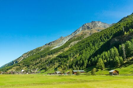 Mountain and small town during the sunshine day in Switzerland. Autumn season