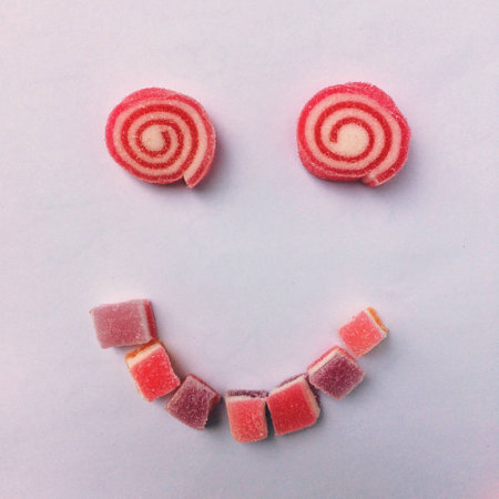 A smiling face made from jelly marshmallow coated by sugar.の素材