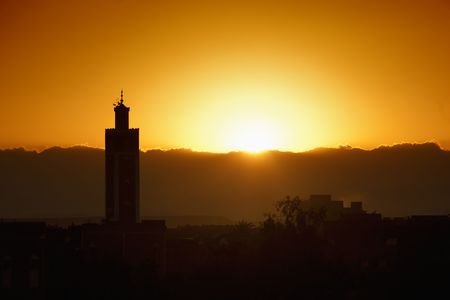 a minaret of a mosque with sunset as background. Symbol of islam, ramadan, prayerの写真素材