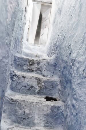 Stone staircase with old, wooden door in the medina of Chefchaouen, Morocco.の写真素材