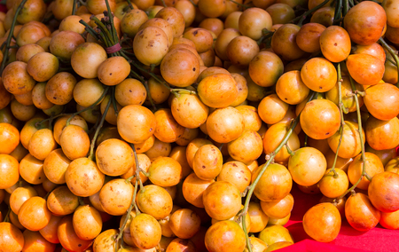 A group of Rambeh Fruit placed on a red cloth, sold in the market.の写真素材