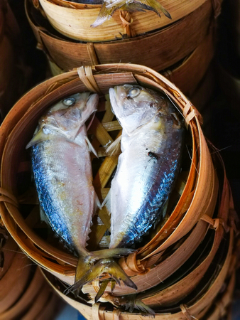 Top view images Mackerel steamed in woven bamboo tray which overlap with flies on a mackerel.の写真素材
