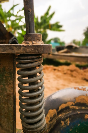 Coil spring of tractor on natural background blur.の写真素材