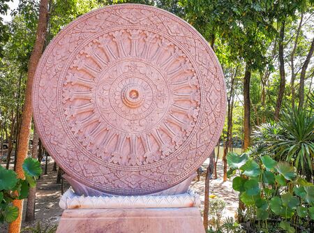 The Thammachak wheel is carved from stone as a symbol of Buddhism.の写真素材