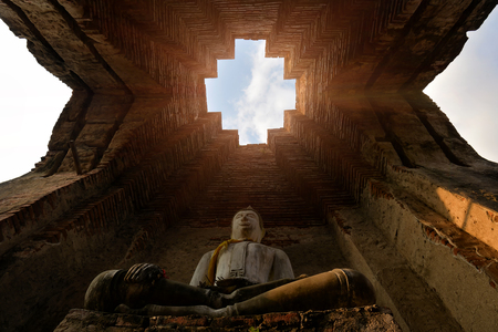 Asian religious architecture. Ancient sandstone sculpture of Buddha at Prasat Nakhon Luang in Ayutthaya, Thailand.の写真素材