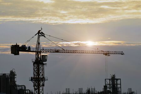 Silhouette tower cranes build large residential buildings  at construction site .の写真素材