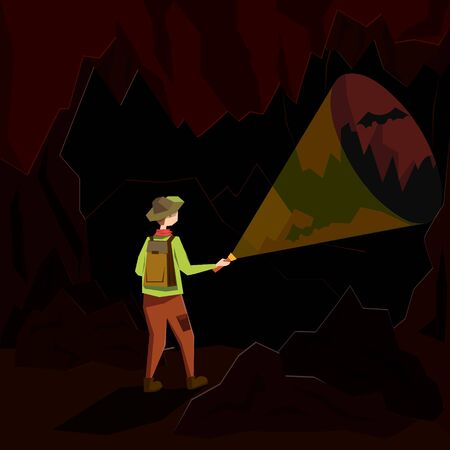A young man stands in a dark cave and illuminates his path with a lantern.のイラスト素材
