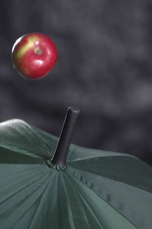 An apple falling on an umbrella.の写真素材