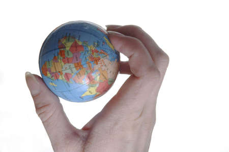 A hand holding a miniature globe. The western hemisphere is visible.