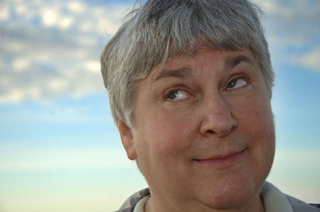 A gray-haired woman rolls her eyes.の写真素材