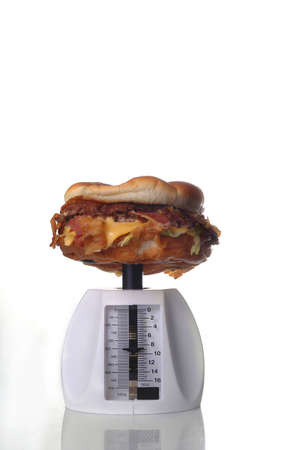 A hamburger on a food scale against a white background.の写真素材