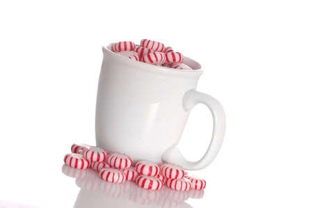 A cup full of peppermint candy isolated against a white background.の写真素材