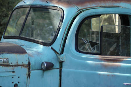 Detail of an old rusty pickup truck with a cracked window.