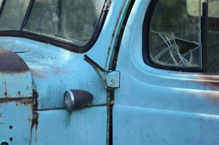 Detail of an old rusty pickup truck with a cracked window.の写真素材