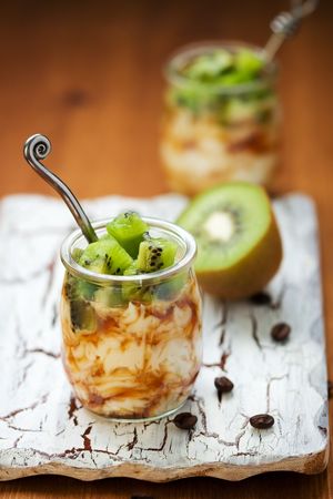 Ricotta cream with fresh kiwi and coffee in a glass jarの写真素材