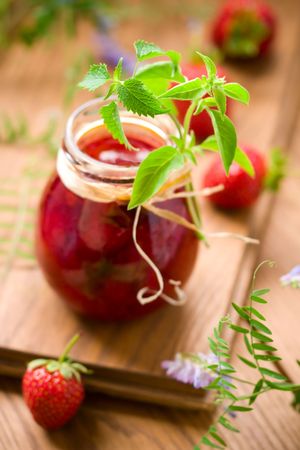 A jar of strawberry jam with basil and mintの写真素材