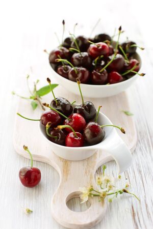  fresh red cherry in the bowl on the cutting boardの写真素材