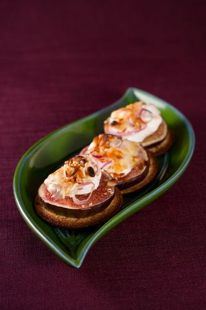 Delicious appetizers topped with goat cheese,fig,nut and sweet onion