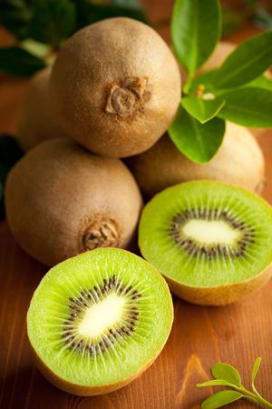 Fresh ripe kiwi with leaves on the wooden tableの写真素材