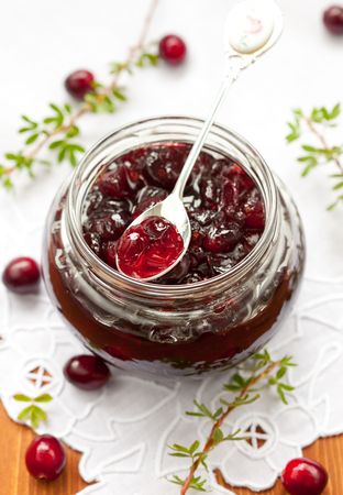 Jar of cranberry jam and some fresh berries on the tableの写真素材