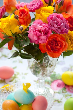 bouquet  of multi-colored roses in vase and easter eggsの写真素材