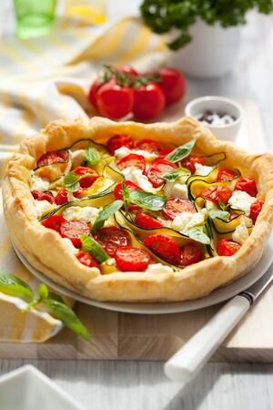 Quiche with tomato,zucchini and cheese with basilの写真素材