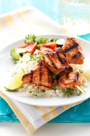 Delicious chicken masala skewers with rice and vegetable salad.の写真素材