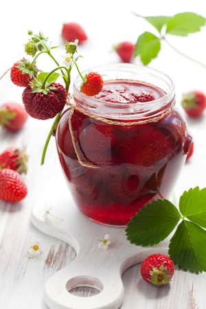 strawberry jam in a jar and fresh berries on the wooden tableの写真素材