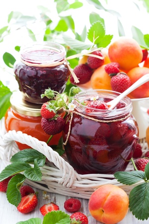 strawberry,apricot, raspberry jam in a jars and fresh berriesの写真素材
